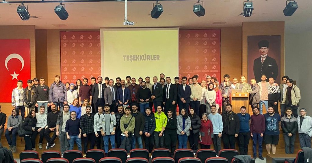 Üniversite etkinliğinin sonunda sahnede bir araya gelen katılımcılar